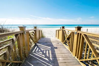 a wooden path to the beach with the ocean in the background at Grand Panama 1-1807 in Panama City Beach