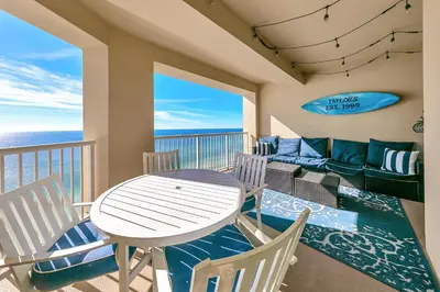 a balcony with a table and chairs and a couch at Grand Panama 1-1807 in Panama City Beach