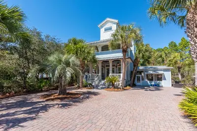 a house with palm trees and a brick driveway at Tucked Away in Inlet Beach