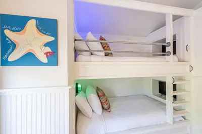 a childs bunk bed in a white bunk room at Tucked Away in Inlet Beach