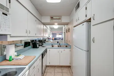 a kitchen with white cabinets and white appliances at Regency Towers PCB Condo Beach Access and 2 Pools in Panama City Beach