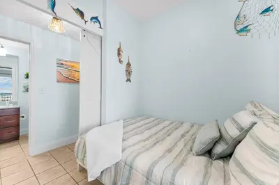 a white bedroom with a bed and a bathroom at Laketown Wharf #624 Beautiful Gulf View by Nautical Properties in Panama City Beach