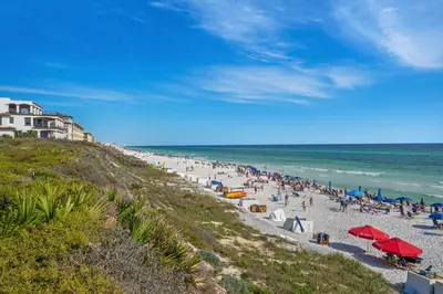 a group of people on a beach near the ocean at Mi CaSEAta in Rosemary Beach