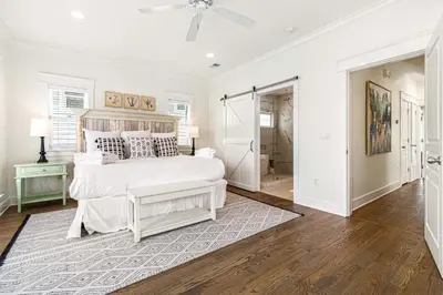 a white bedroom with a large bed and a bathroom at Mi CaSEAta in Rosemary Beach
