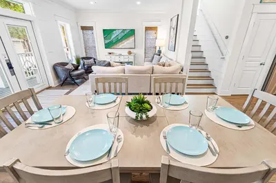 a dining room with a wooden table and chairs at Mi CaSEAta in Rosemary Beach