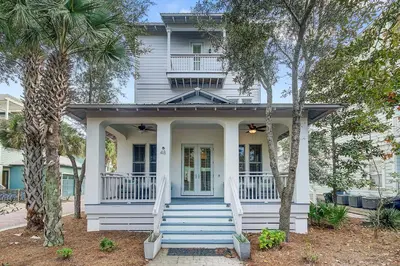 a white house with palm trees in front of it at Surf on Turf -Whole House in Rosemary Beach
