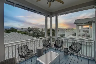 a porch with chairs and a table on it at Surf on Turf -Whole House in Rosemary Beach
