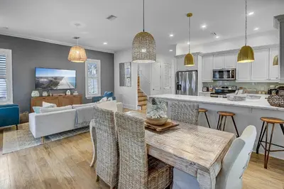 a kitchen and living room with a table and chairs at Surf on Turf -Whole House in Rosemary Beach