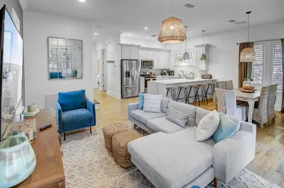 a living room with a couch and a kitchen at Surf on Turf -Whole House in Rosemary Beach