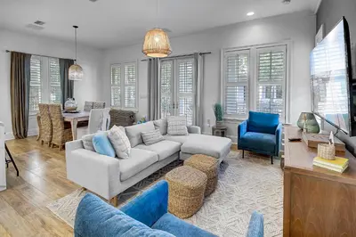a living room with a white couch and blue chairs at Surf on Turf -Whole House in Rosemary Beach
