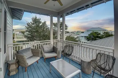 a porch with chairs and a coffee table on it at Surf on Turf -Whole House in Rosemary Beach