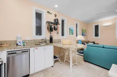a kitchen with a table and a blue couch at Grand Tortuga Squirt in Panama City Beach