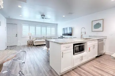 a kitchen with white cabinets and a counter top at Suite Y'all in Santa Rosa Beach