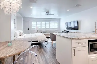 a kitchen and living room with a bed and a table at Suite Y'all in Santa Rosa Beach
