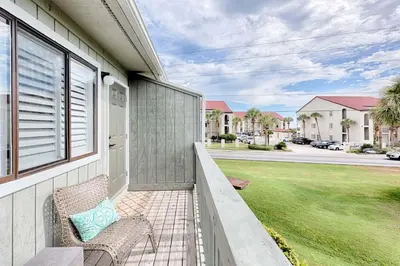 a porch of a house with a chair and a yard at Suite Y'all in Santa Rosa Beach