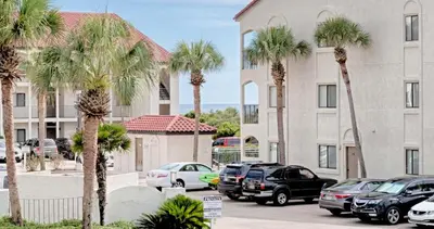 a parking lot with palm trees in front of a building at Suite Y'all in Santa Rosa Beach