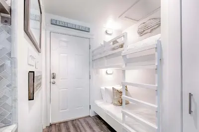 a walk in closet with a white door and shelves at Suite Y'all in Santa Rosa Beach
