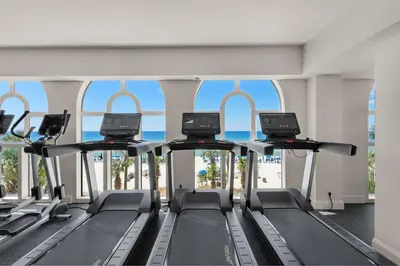 a gym with a row of treadmills at 1005 Calypso Direct Ocean Front Master on the Gulf in Panama City Beach