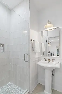 a white bathroom with a sink and a shower at The Magnolia Mermaid in Panama City Beach
