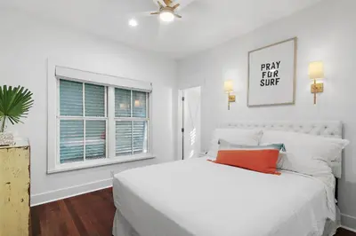 a white bedroom with a bed and a window at The Magnolia Mermaid in Panama City Beach