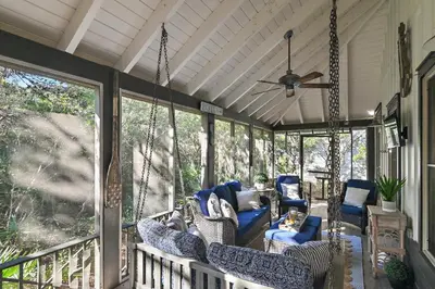 a porch with chairs and a ceiling fan at The Magnolia Mermaid in Panama City Beach