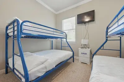 a bedroom with two bunk beds and a flat screen tv at Ten Grand in Santa Rosa Beach