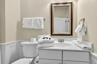 a white bathroom with a toilet and a sink at Tennessee by the Sea in Inlet Beach