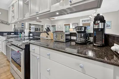 a kitchen with white cabinets and a counter top at Tennessee by the Sea in Inlet Beach