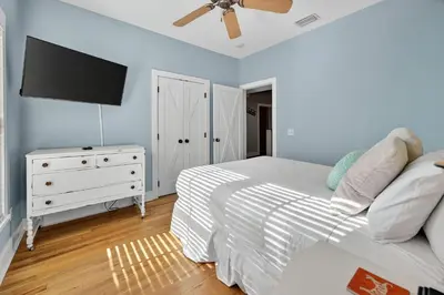 a bedroom with a bed and a flat screen tv at Tennessee by the Sea in Inlet Beach