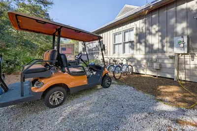 an orange golf cart parked next to a building at Tennessee by the Sea in Inlet Beach