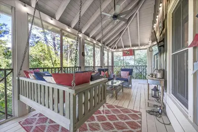 a porch with a swing on a house at Tennessee by the Sea in Inlet Beach