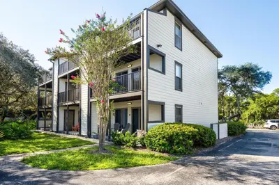 an apartment building with a tree in front of it at Wonderful World in Inlet Beach