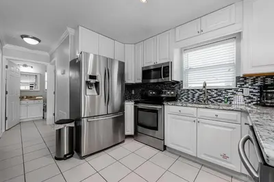 a kitchen with stainless steel appliances and white cabinets at Rollin Tides in Santa Rosa Beach