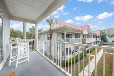 a balcony with a white railing and a house at Rollin Tides in Santa Rosa Beach