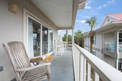 a porch with a rocking chair and a table at Rollin Tides in Santa Rosa Beach