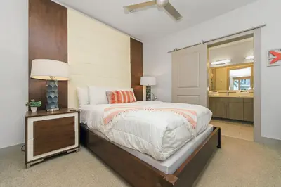 a bedroom with a bed and a dresser with a lamp at Shore Beats Workin' in Inlet Beach