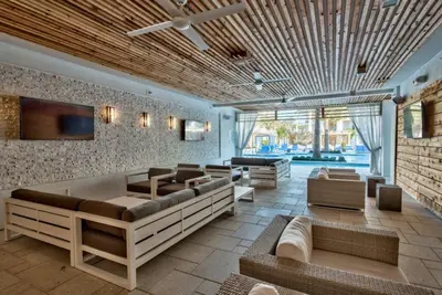 a living room with couches and chairs and a ceiling at Shore Beats Workin' in Inlet Beach