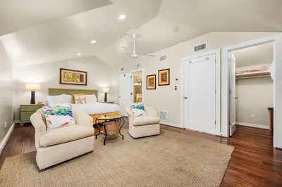 a bedroom with a bed and two chairs and a table at Grand Tortuga Crush in Panama City Beach