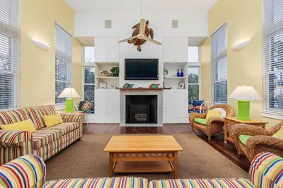 a living room with couches and a fireplace at Grand Tortuga Crush in Panama City Beach