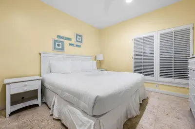 a bedroom with a large white bed and a window at Grand Tortuga Crush in Panama City Beach