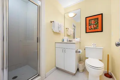 a bathroom with a toilet and a glass shower at Grand Tortuga Crush in Panama City Beach