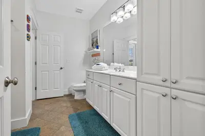 a white bathroom with a sink and a toilet at Cute as a Button in Inlet Beach