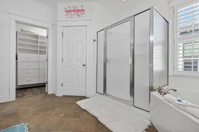 a white bathroom with a shower and a sink at Cute as a Button in Inlet Beach