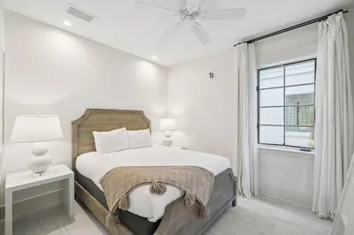 a white bedroom with a bed and a window at Summer Breeze by 30A Escapes in Rosemary Beach