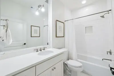 a white bathroom with a sink and a toilet at Summer Breeze by 30A Escapes in Rosemary Beach