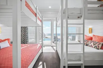 a bedroom with bunk beds with a view of the ocean at The Sand Castle by 30A Escapes in Panama City Beach