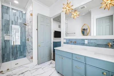 a bathroom with a blue vanity and a shower at The Sand Castle by 30A Escapes in Panama City Beach