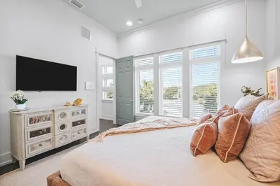 a bedroom with a large bed and a flat screen tv at The Sand Castle by 30A Escapes in Panama City Beach