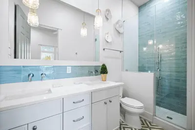 a bathroom with a sink and a toilet and a mirror at The Sand Castle by 30A Escapes in Panama City Beach