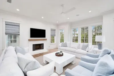 a living room with white furniture and a fireplace at Paralia 30A in Seagrove Beach